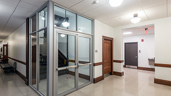 Commercial stairwell with glazed fire door, internal corridor, and secure entry system