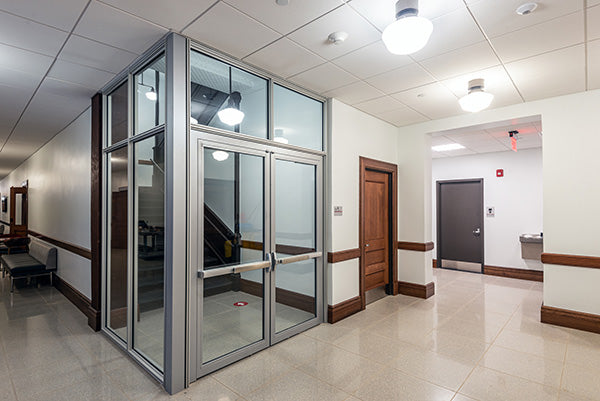 Commercial stairwell with glazed fire door, internal corridor, and secure entry system